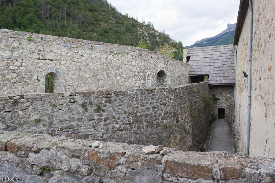 fort-savoie-044.jpg - Colmars-les-Alpes - Le Fort de Savoie - Extérieur de la deuxième enceinte. A gauche la courtine Ouest, au fond en haut, les cuisines, en dessous la poudrière et à droite en haut la Salle d'Armes et dessous la salle des officiers et celles, au nombre de trois des soldats.