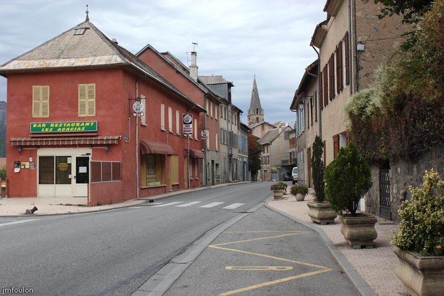 remollon-03web.jpg - La D 900b qui traverse le village. La Bourgade, partie la plus ancienne du bourg, se trouve sur la gauche