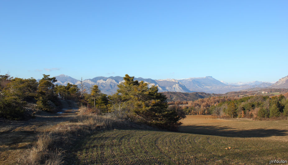 theze-tour-chenes_059.JPG - Prenons cette piste pour descendre à gauche à une centaine de mètres par un sentier, vers la ferme du Pita et Thèze. Au loin à droite au second plan, la montagne de Céüse (2016 m) au plateau bordé d'une falaise