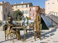 Martigues - L'île  Statues de bronze, représentant Fernandel et Bourvil dans une scène emblématique de " la cuisine au beurre ". Le sculpteur Sébastien Langloÿs, a laissé trois chaises à disposition pour que les touristes et locaux y prennent place. 1/2