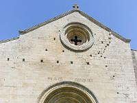 Salagon  Façade Sud - l'entrée surmontée d'un occulus. On voit de nombreux trous de boulins qui servait à encrer les échaffaudages de bois lors de la construction ...
